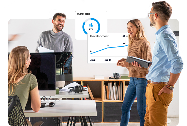 Mennesker på kontor, der står og snakker, grafer i baggrunden