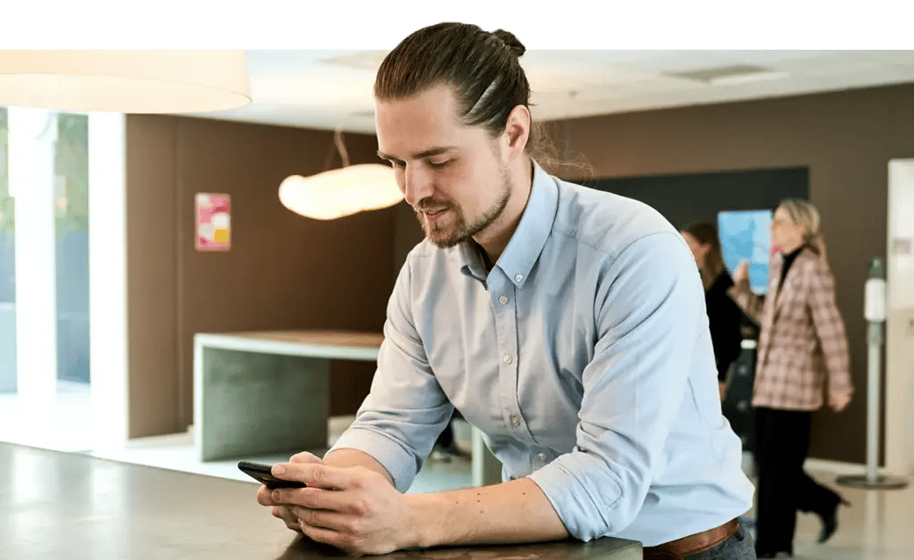 Mand står med sin telefon og svarer på eNPS survey