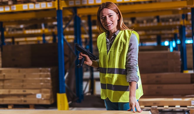 Kvinde med gul arbejdsvest i lagerhal